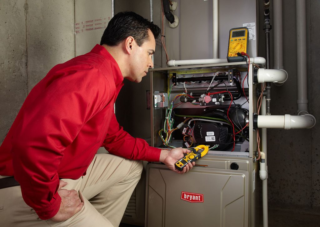 Heating and air conditioning technician servicing an indoor furnace in Westminster, CO