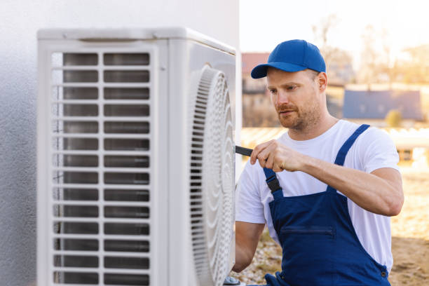 Air conditioning technician servicing an outdoor AC unit for HVAC maintenance