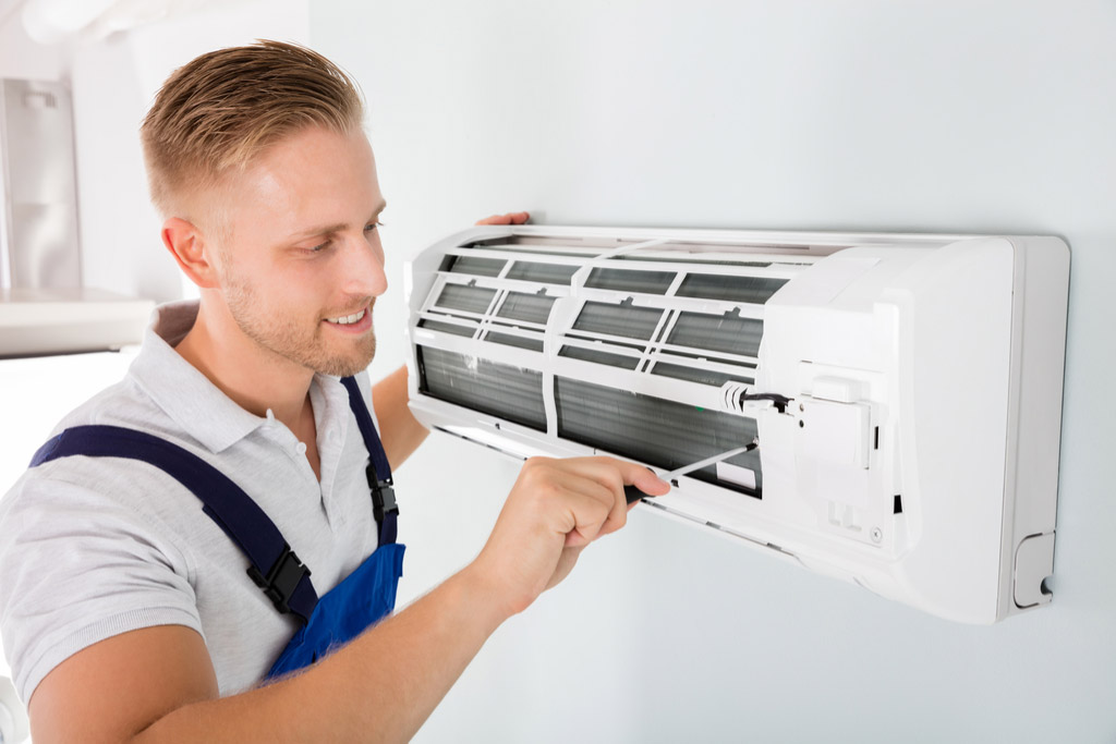 HVAC technician performing ductless air conditioning maintenance in Westminster