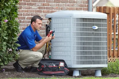 HVAC technician inspecting an outdoor air conditioning unit in Westminster, CO