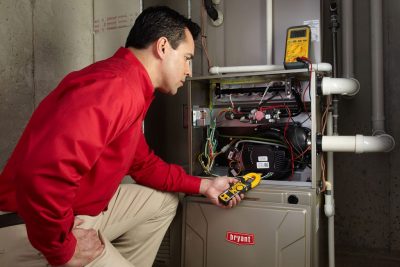 Heating and air conditioning technician servicing an indoor furnace in Westminster, CO